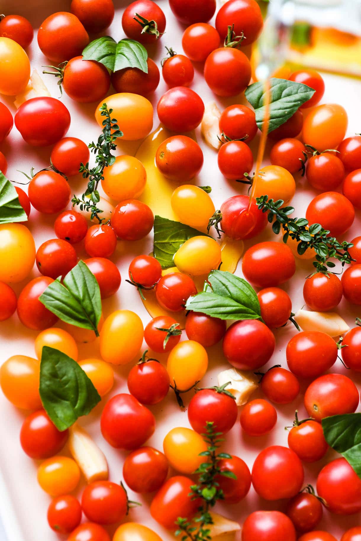 slow roasted cherry tomatoes, olive oil being poured on top