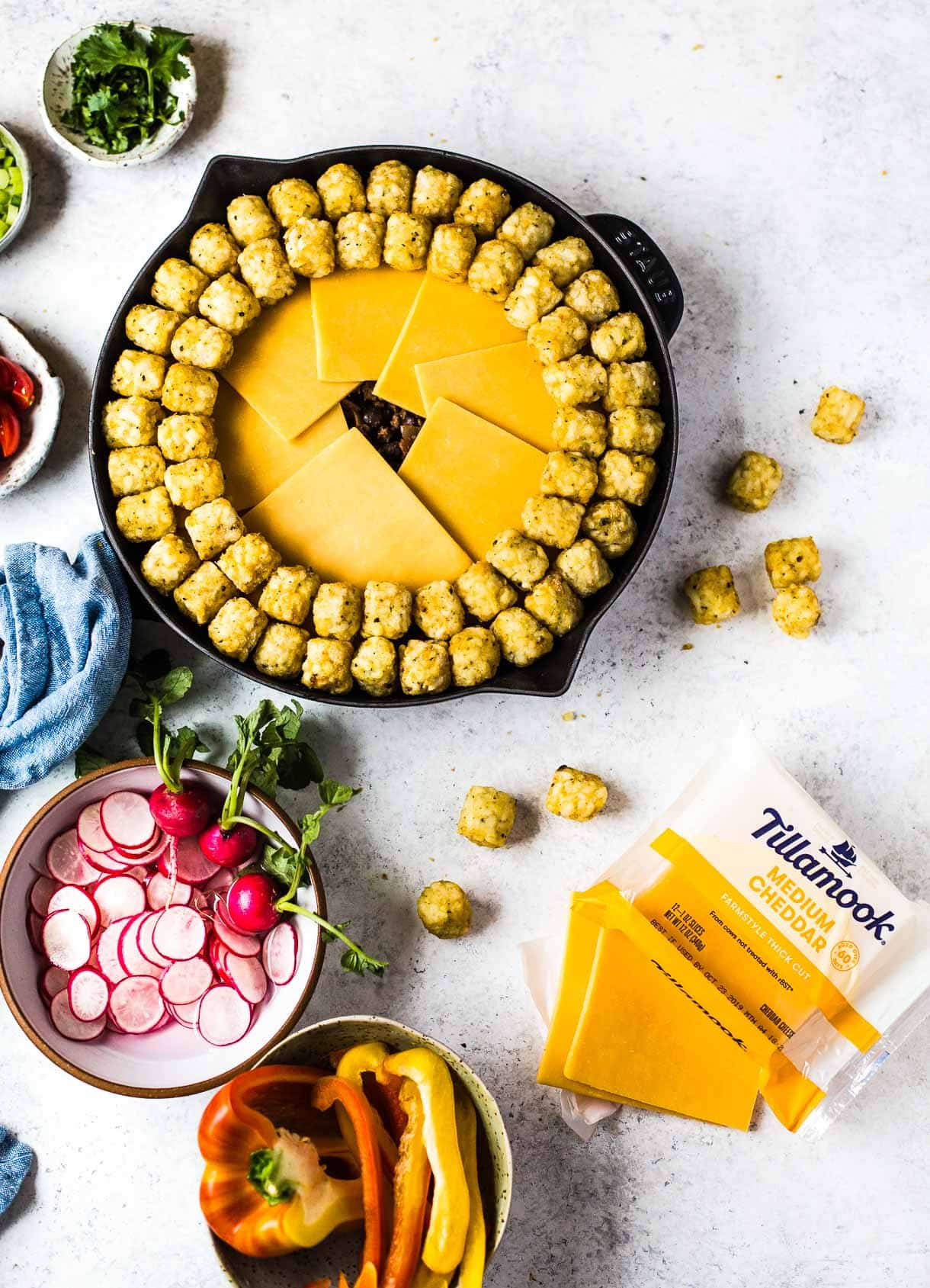 assembling tater tot hotdish with tillamook cheese