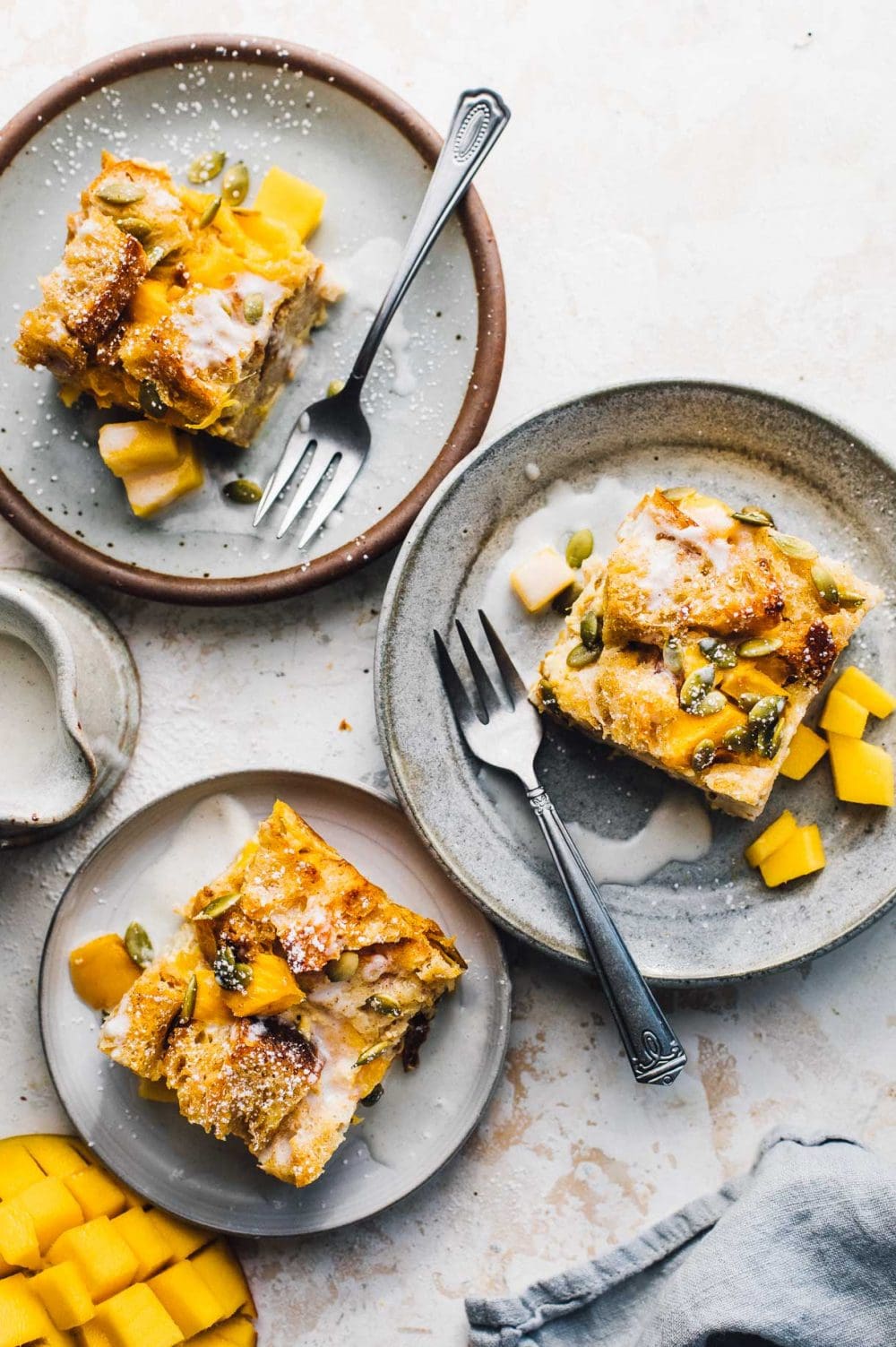 3 small plates with mango bread pudding