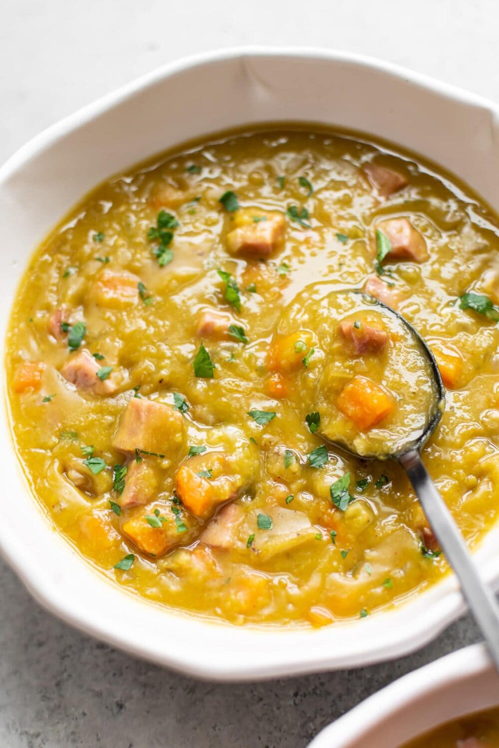 split pea soup in white bowl, with spoon