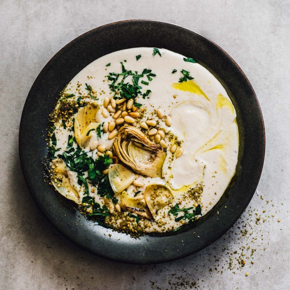 white bean hummus on a black plate