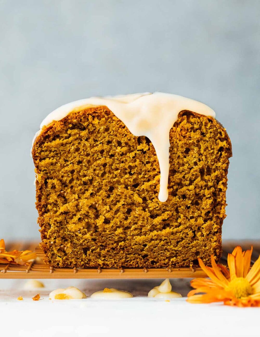 sourdough discard pumpkin bread with maple glaze dripping down front