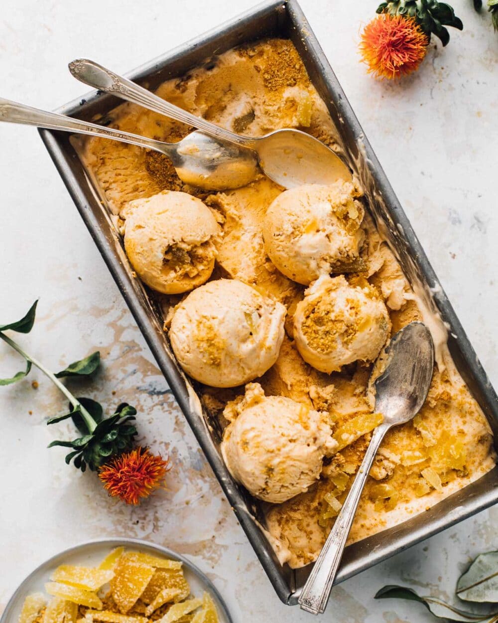 pumpkin pie ice cream in loaf pan with spoons and scoops. 