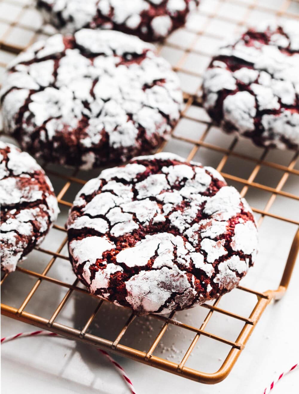 red velvet crinkle cookies on copper cooling rack
