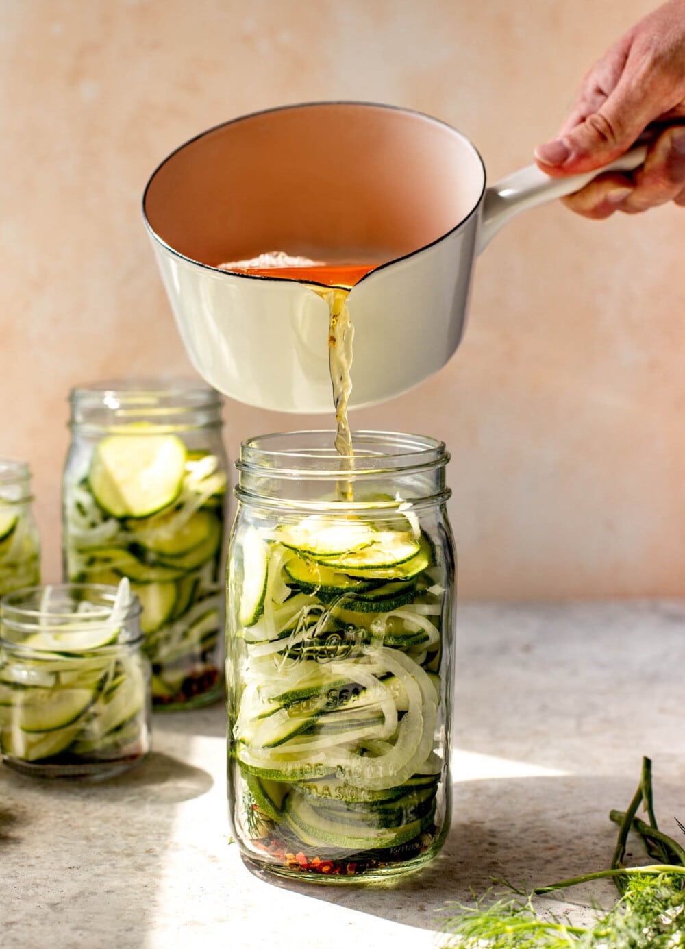 pouring brine over zucchini and onions 