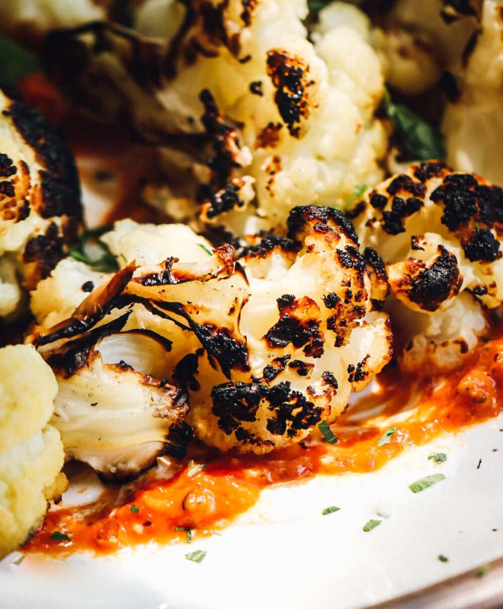 grilled cauliflower florets with red pepper sauce on plate