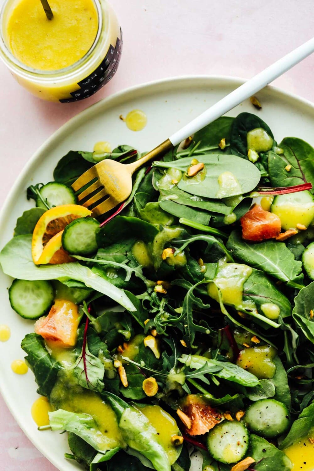 green salad with white balsamic vinaigrette on white plate