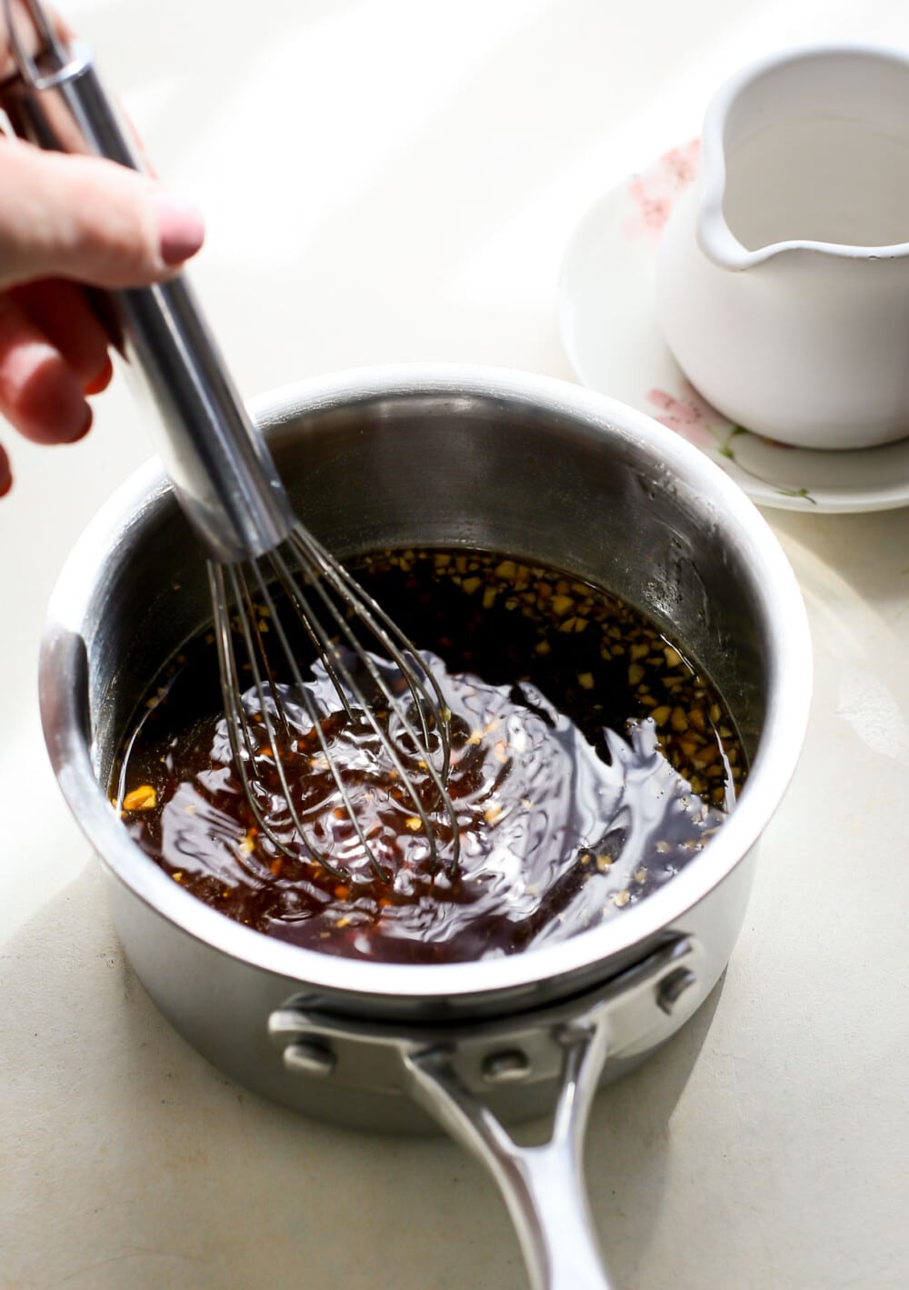 making teriyaki sauce in a saucepan with whisk