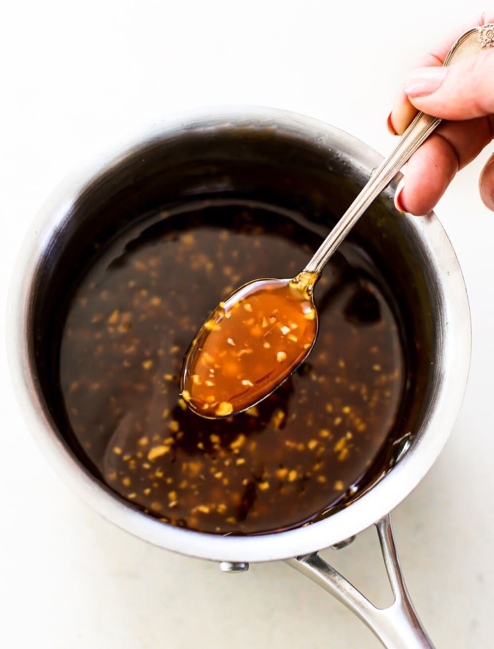 gluten-free teriyaki sauce in a saucepan, with a spoon
