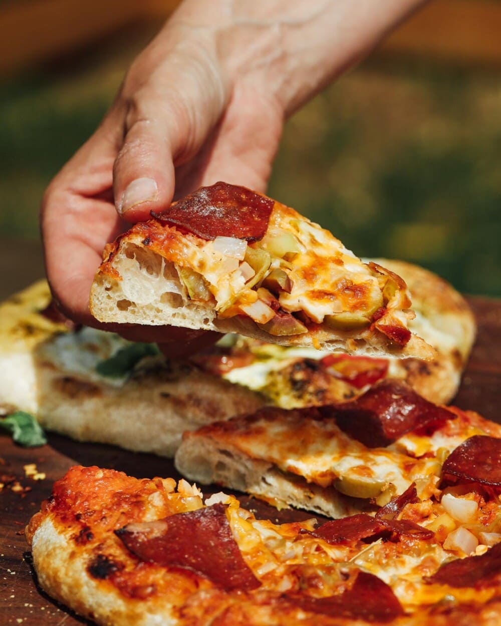 holding a piece of pizza