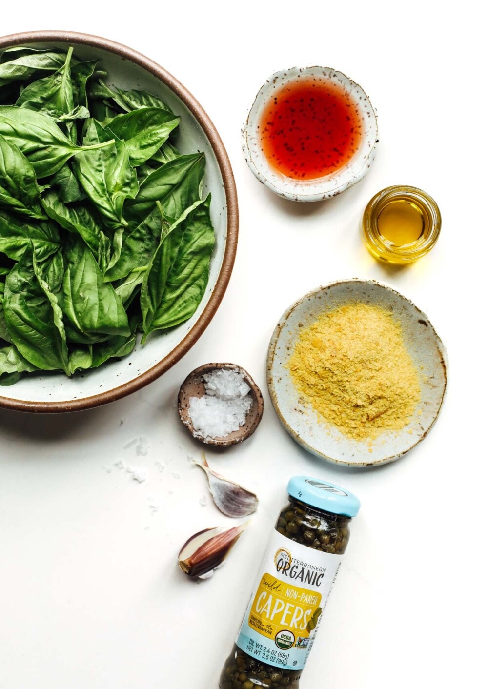 ingredients to make basil vinaigrette on white surface