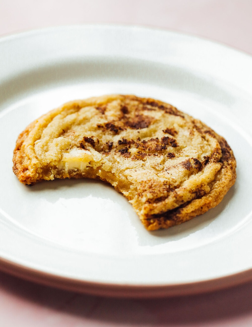gluten free snickerdoodle cookie on a white plate with pink rim