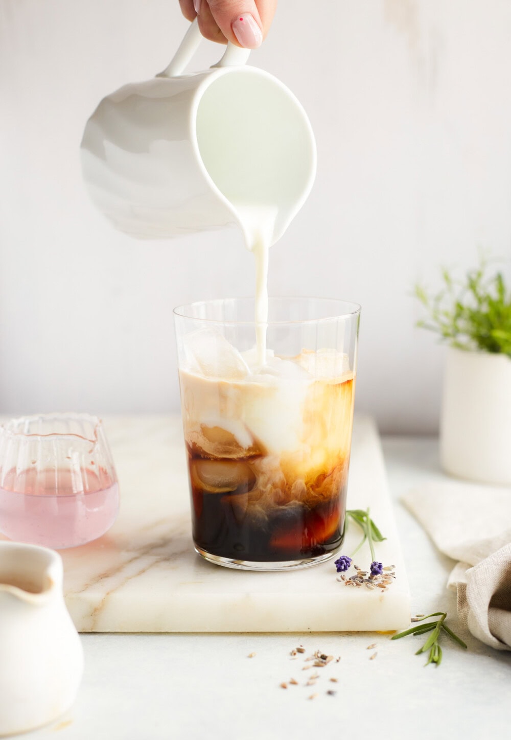 pouring milk into an iced latte