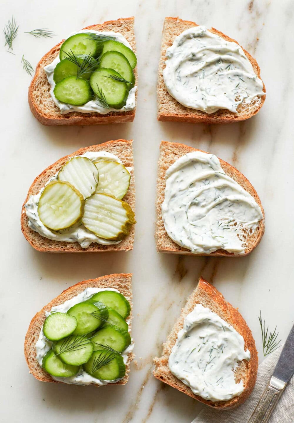 bread with pickles on one side, cream cheese mixture swiped on the other side.