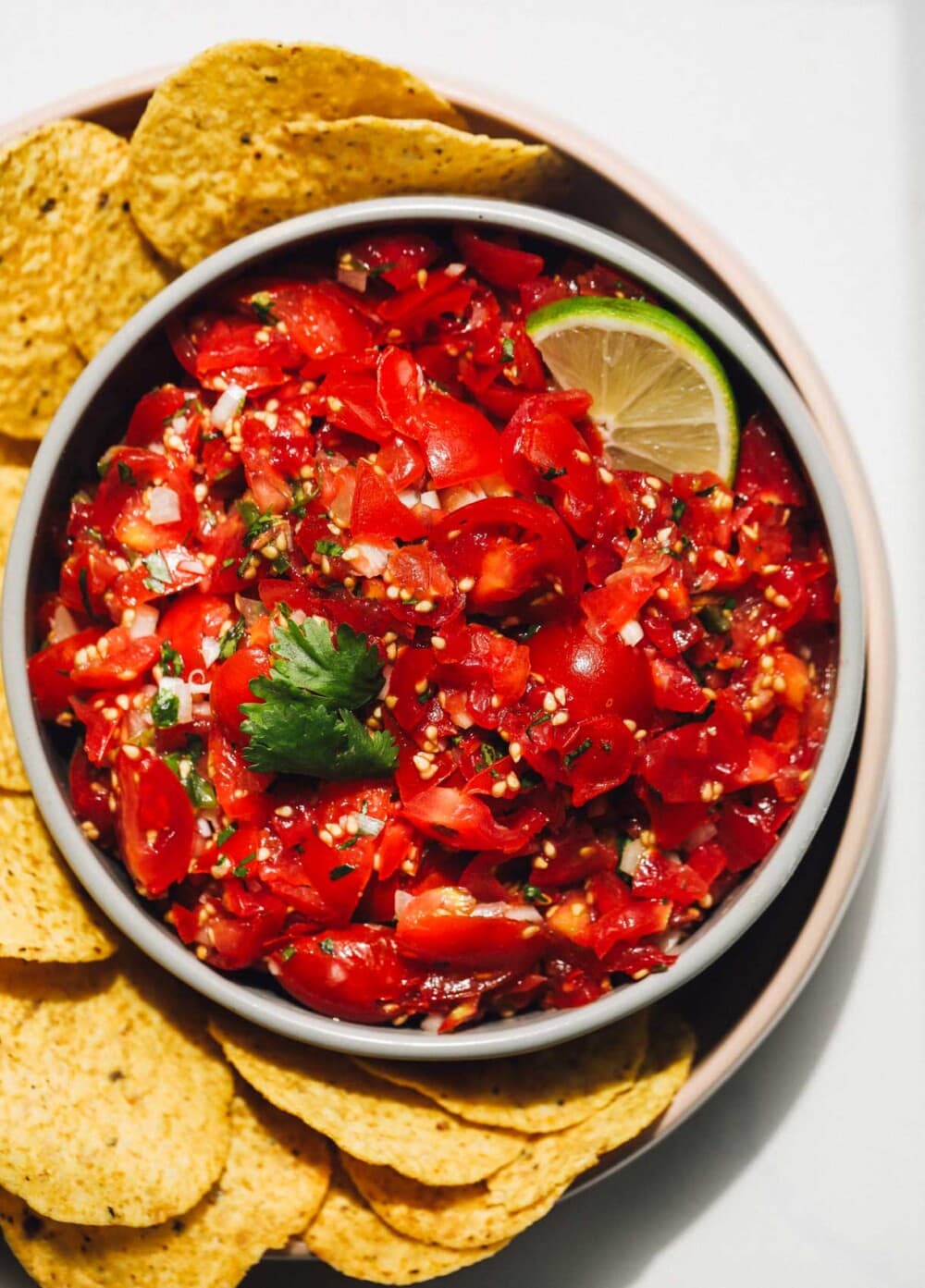 cherry tomato salsa in a bowl surrounded by chips