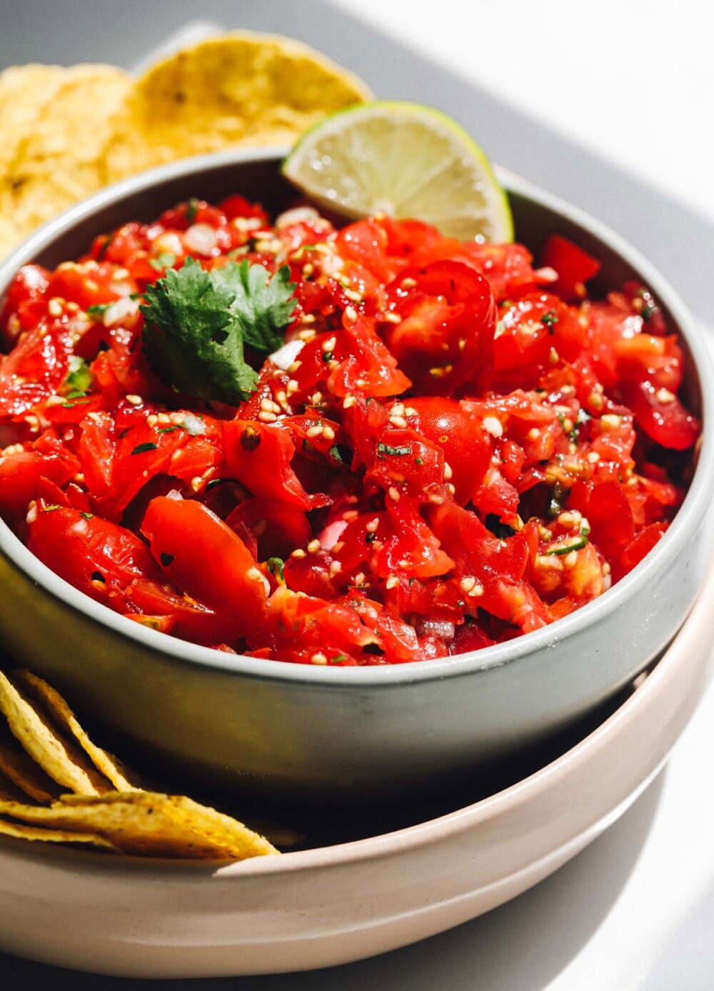 cherry tomato salsa in a bowl surrounded by tortilla chips