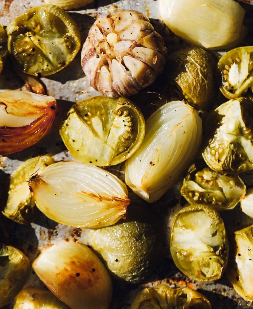 roasted green tomatoes, onion, and garlic on a sheet pan