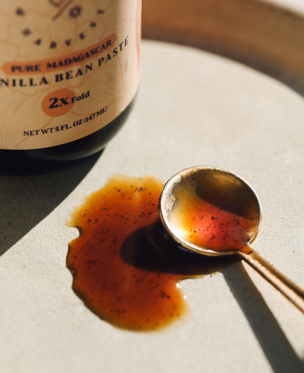 jar of vanilla bean paste with gold spoon