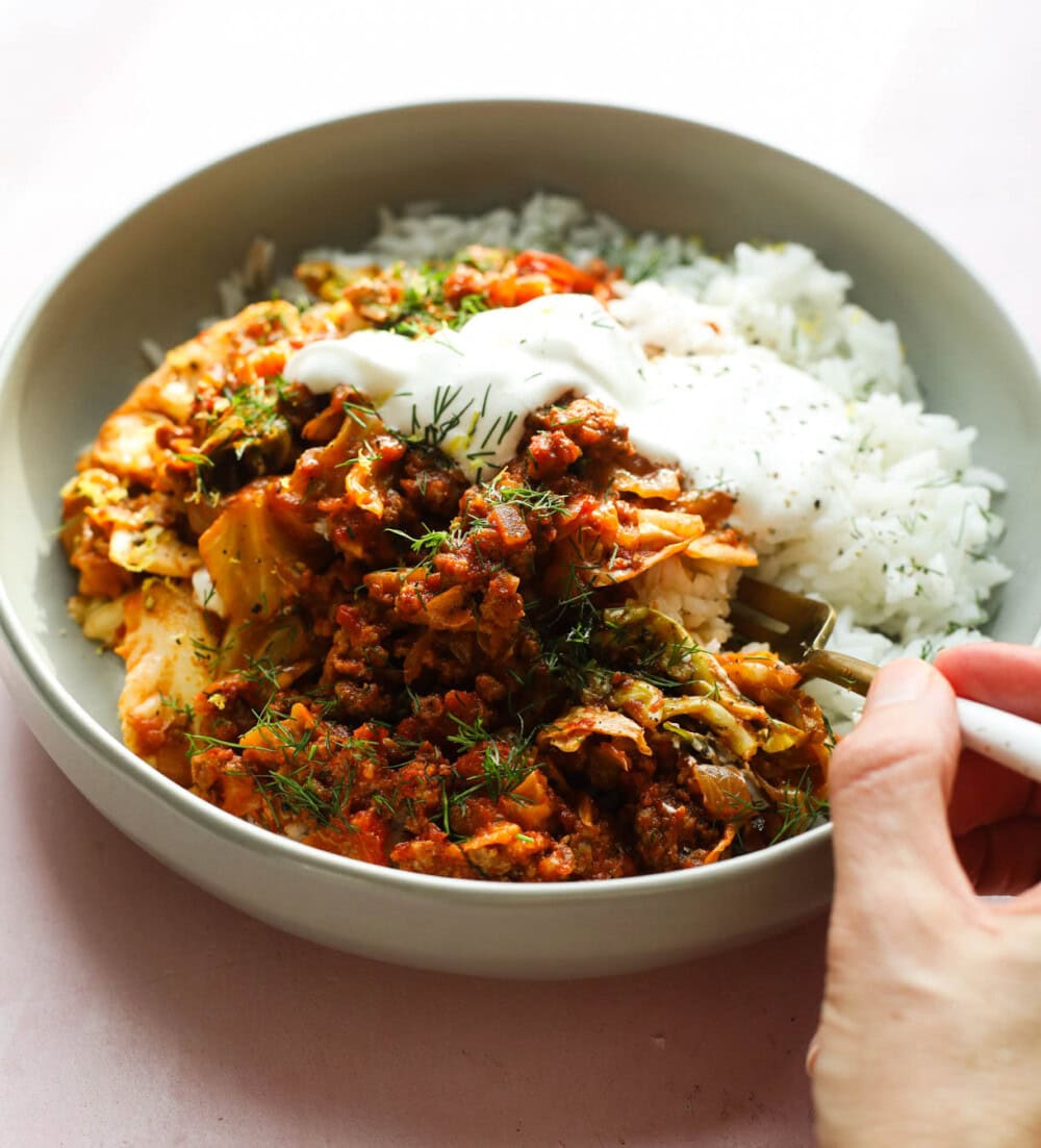 cabbage roll in a bowl bowl with white and gold fork