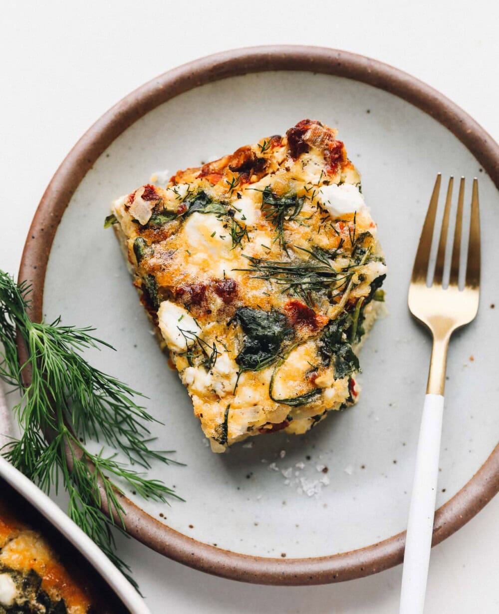 cottage cheese egg bake slice on a blue plate with gold fork