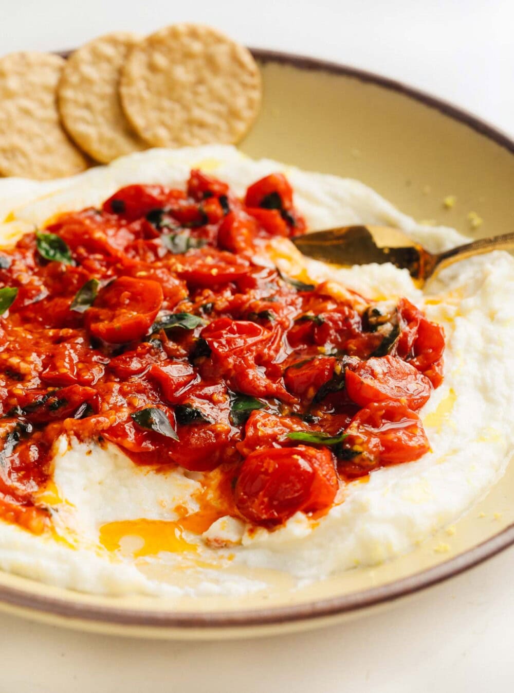 whipped mozzarella with cherry tomatoes on a yellow plate