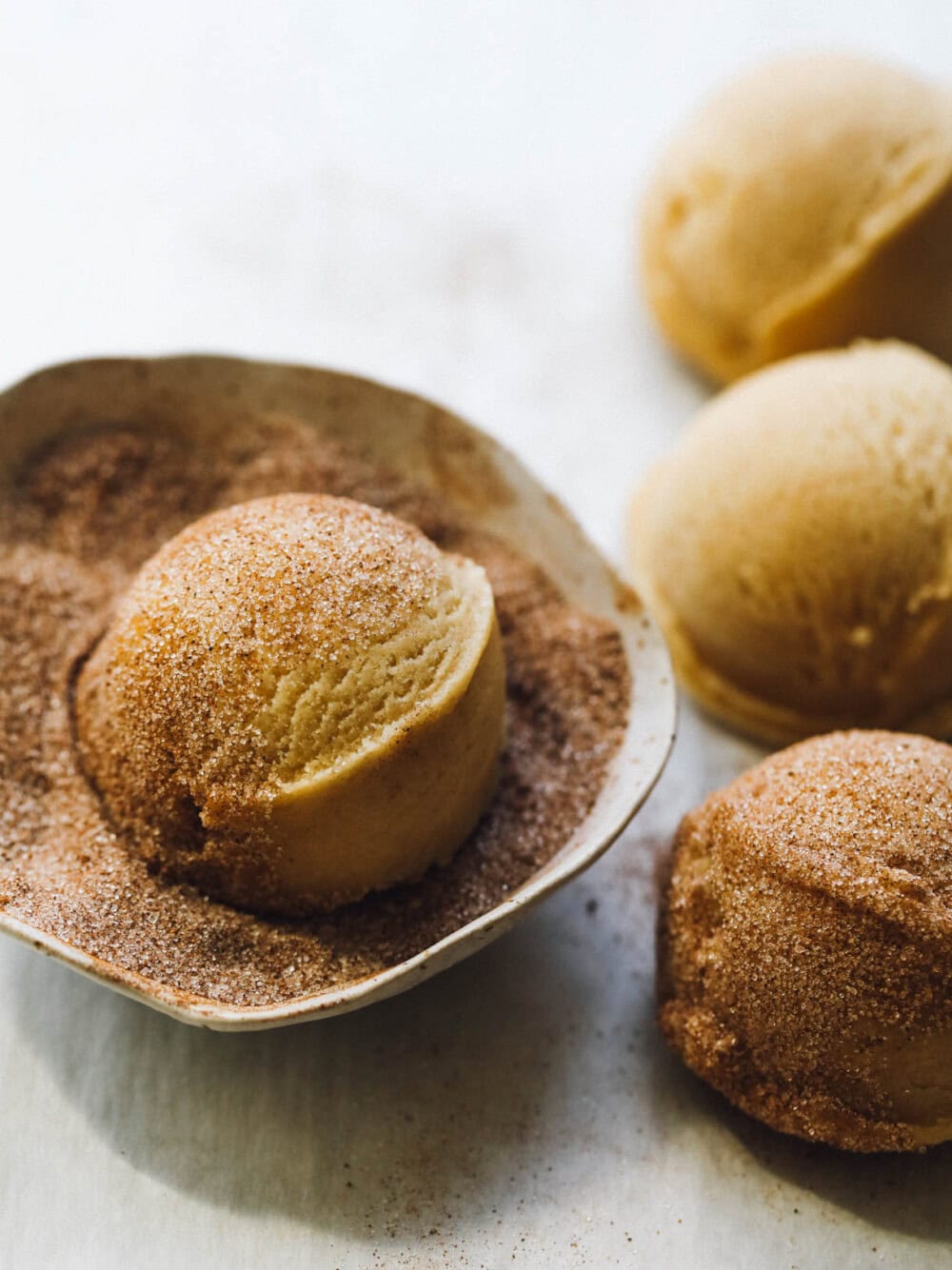 snickerdoodle dough ball in cinnamon sugar dusting. 